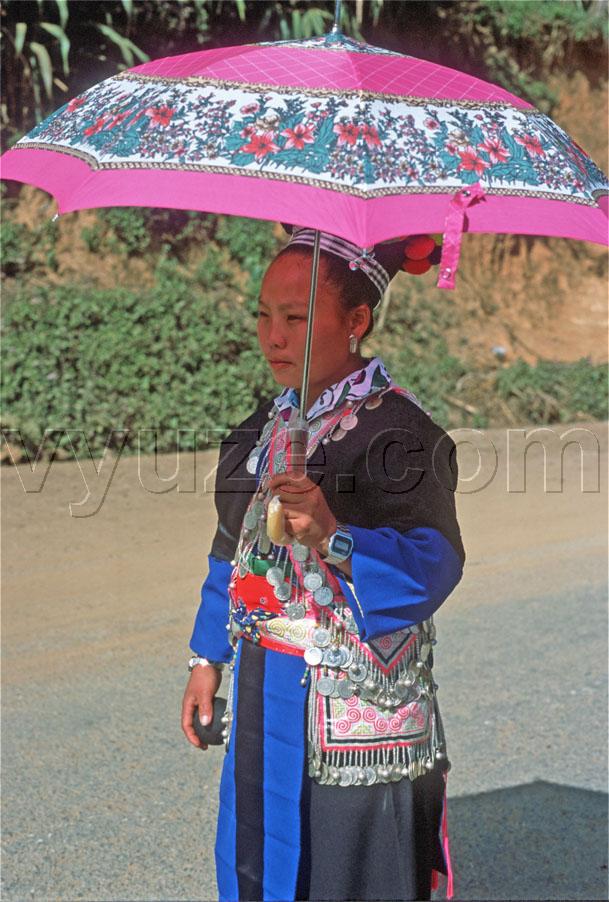 Girl with parasol going to marriage fair / Location: Laos